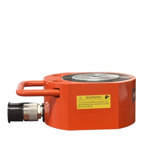 Orange handheld industrial device with a circular top and metal connector on the side, featuring a yellow warning label on the side that reads instructions for safe use.